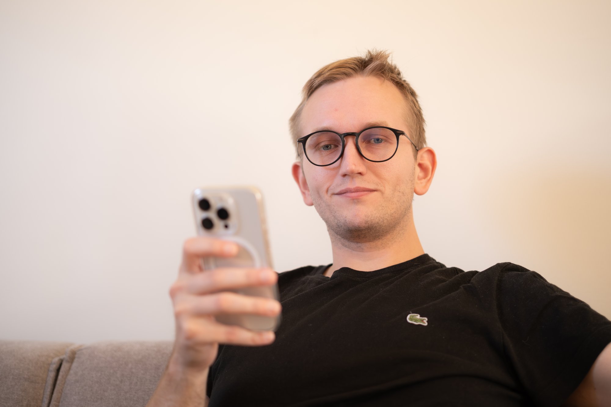 Mann med briller og mobiltelefon ser inn i kamera - Amedia Annonse