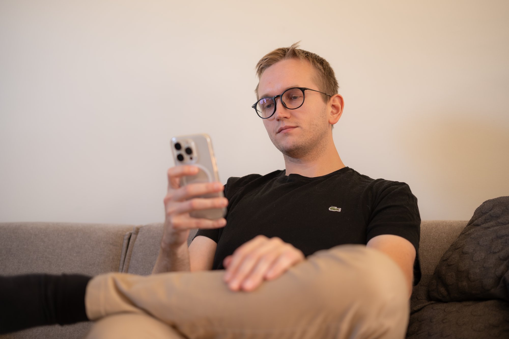 Mann med briller ser på mobiltelefonen - Amedia Annonse