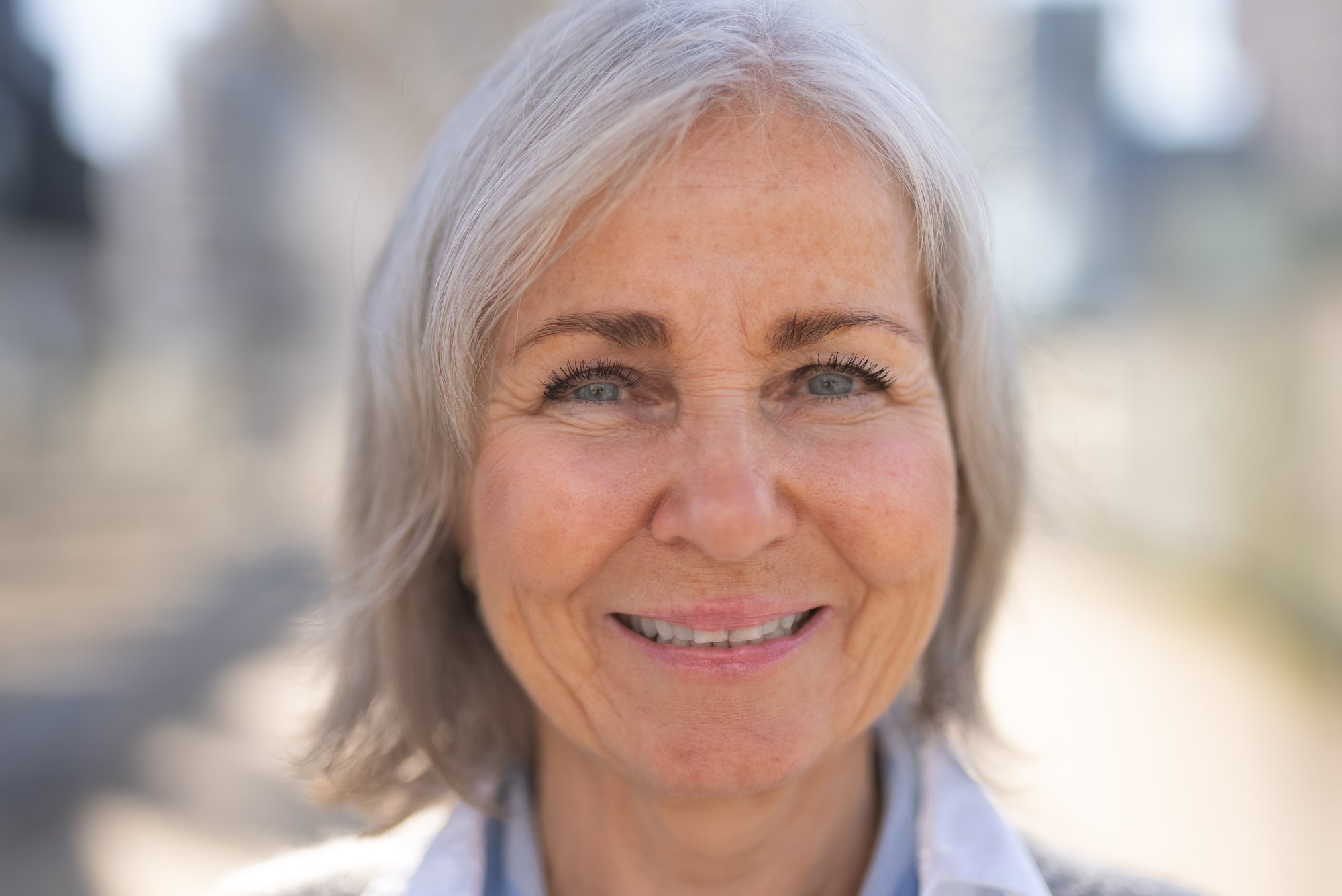 Nærbilde av lett smilende kvinne med lys bakgrunn - Amedia Annonse