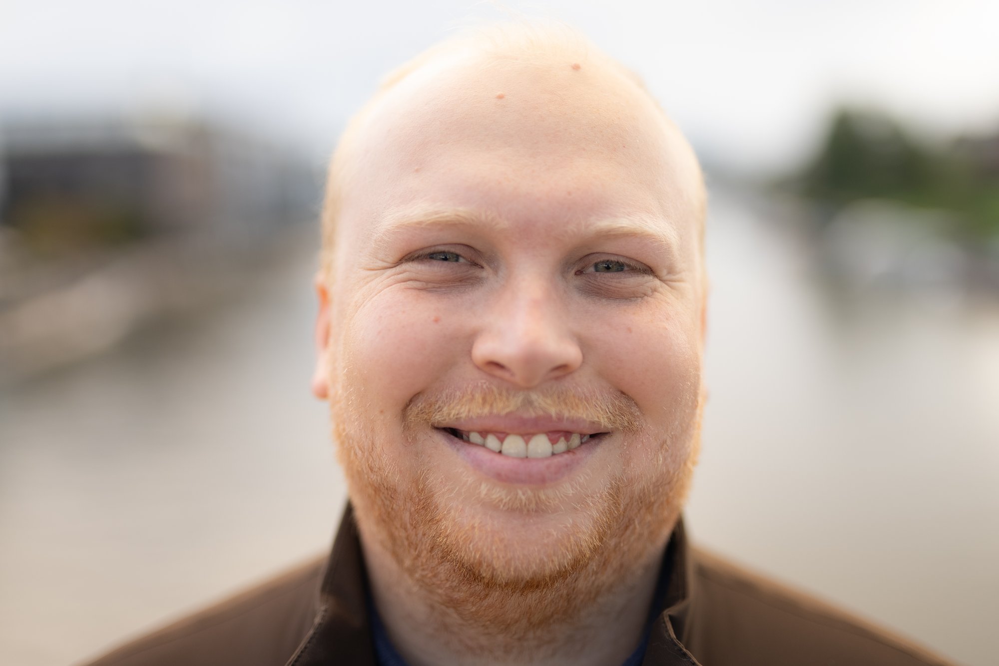 Ung mann smiler til kamera i nærbilde - Amedia Annonse