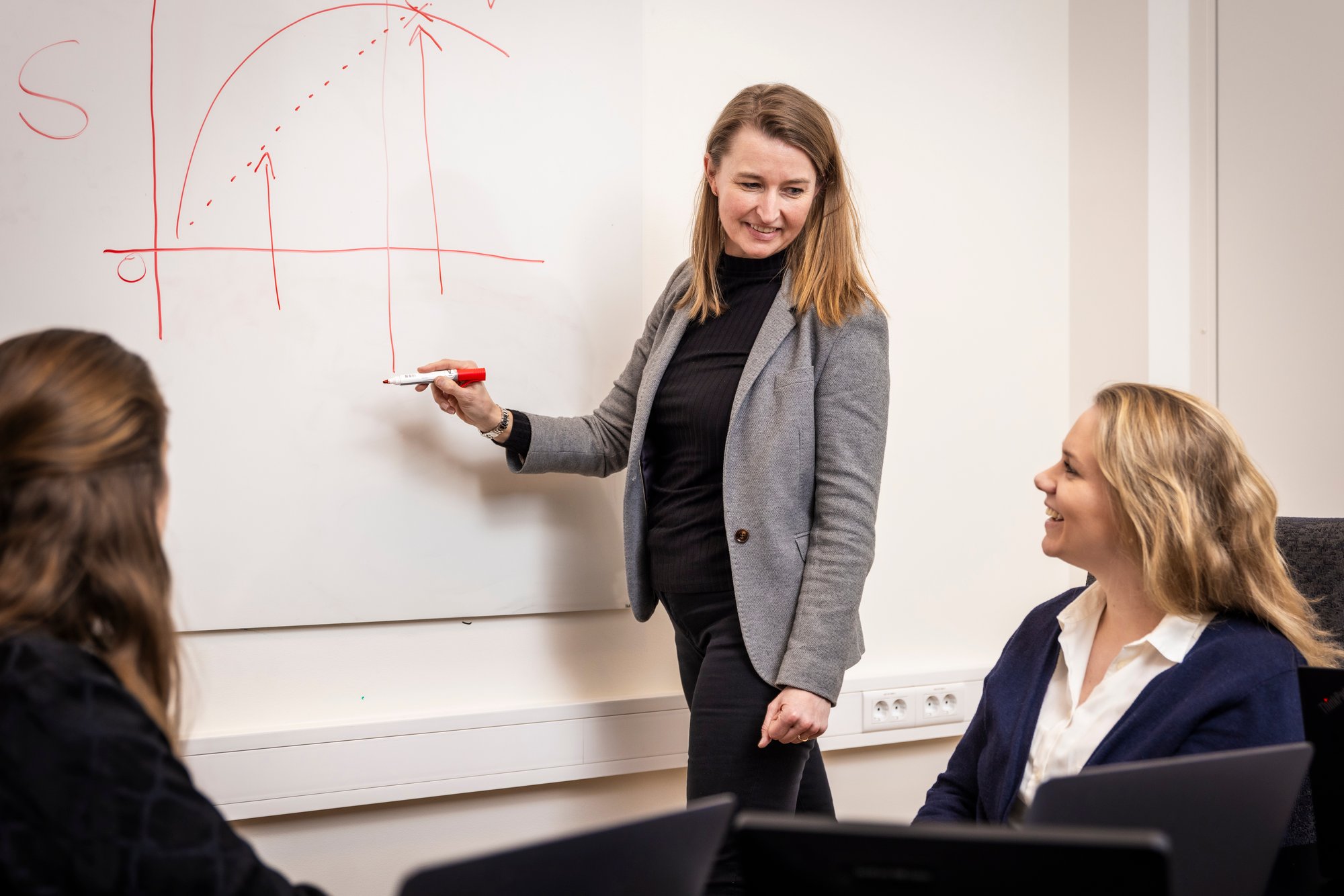 Leder i mediene tegner graf på whiteboard - Amedia Annonse