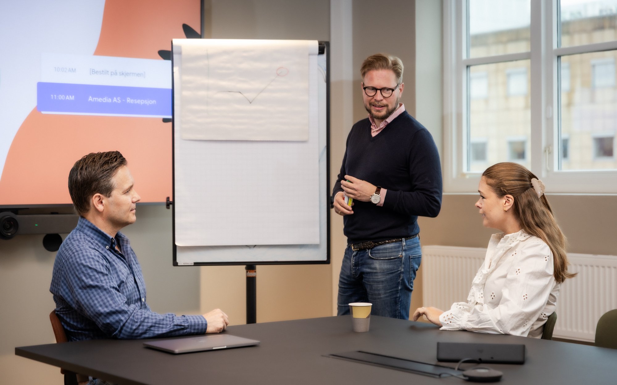 Mann foran flipover snakker til kolleger - Amedia Annonse