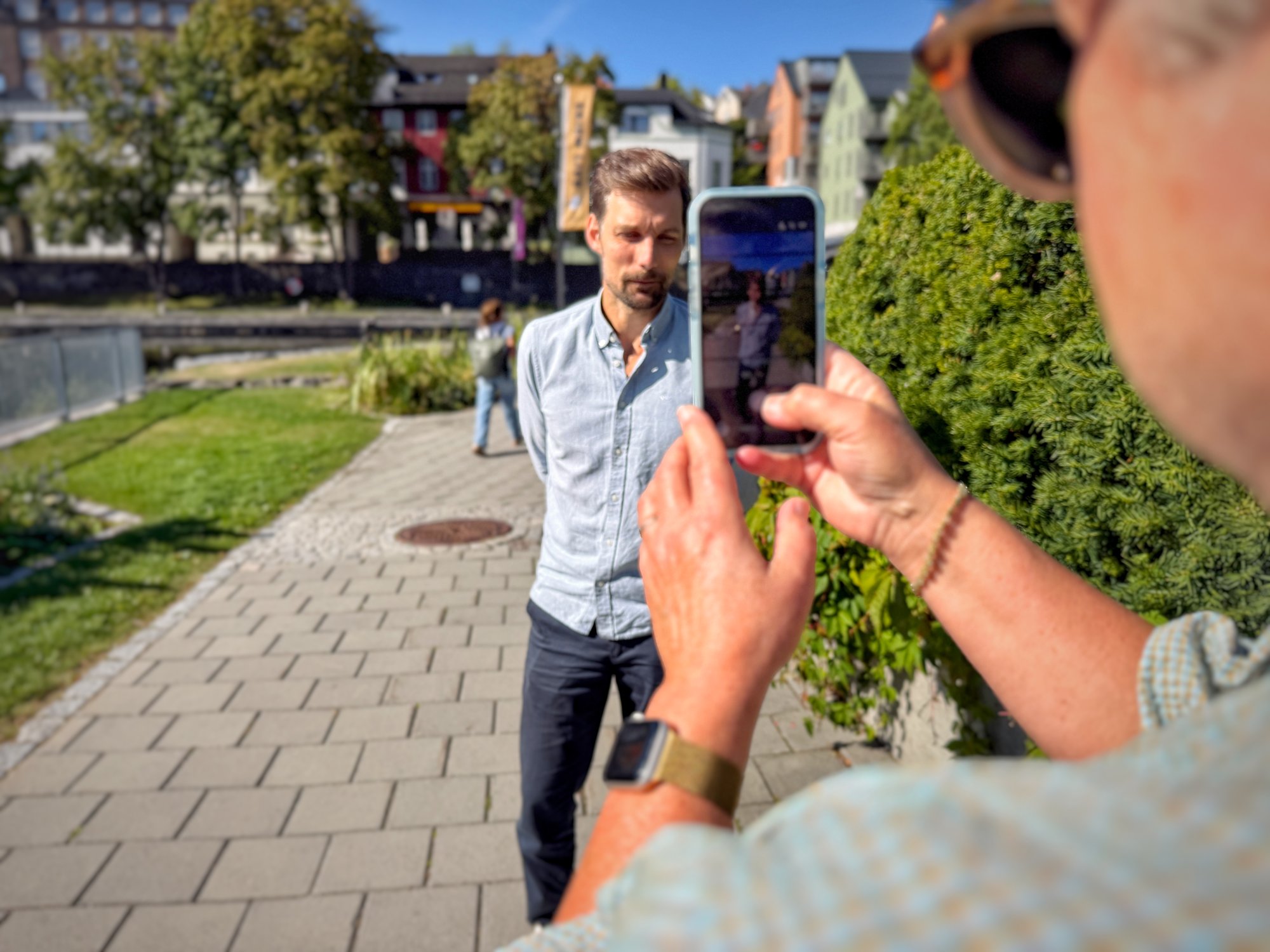 Kvinne filmer mann med mobilen